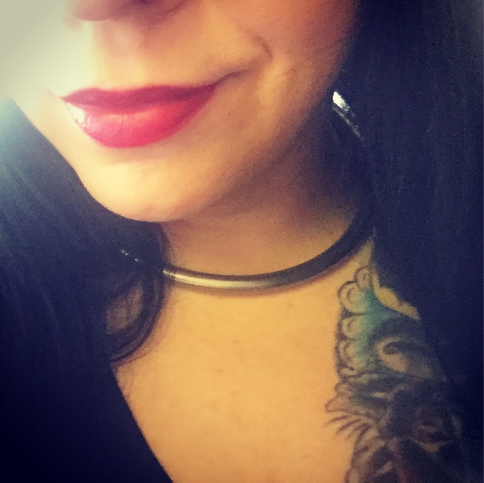 Image of Ducky from lips to lips to collar bones, with red lipstick and a slight smile.