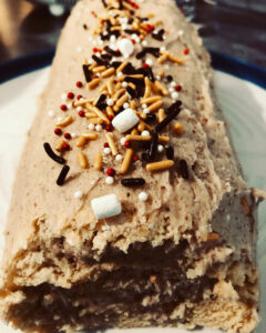 Swiss roll cake with holiday sprinkles on top and a swirly filling center.