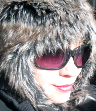 Ducky on a cold yet sunny day, wearing a fur hat, sun glasses, and red lipstick.